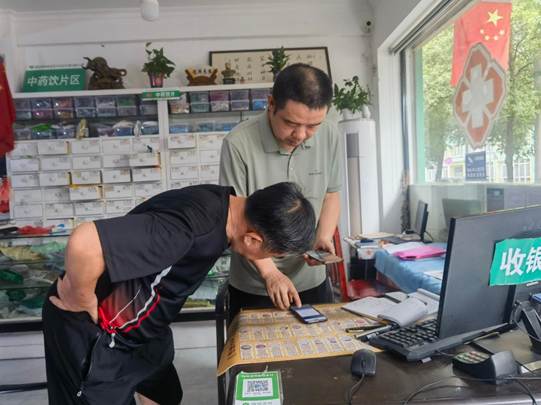 图为邱医生帮助老人在手机上将健康档案从深圳转移至沅江